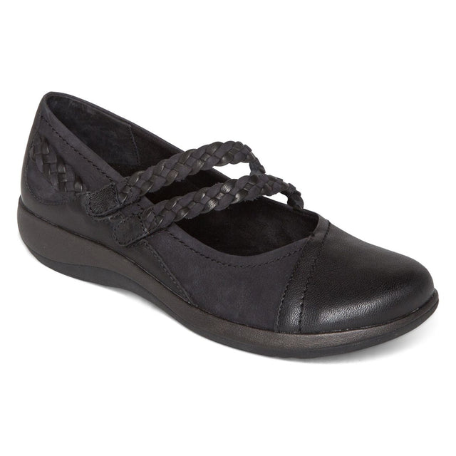 Aetrex Women's Annie Mary Jane. Black orthopedic sandal with two adjustable straps, open toe, and a cushioned footbed with subtle heel lift. Made of smooth leather with a cork and EVA sole, designed for support and comfort.