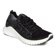 A modern black and white sneaker with breathable mesh upper, white midsole, lace-up front, and low-profile .8-inch heel designed for support and daily comfort.