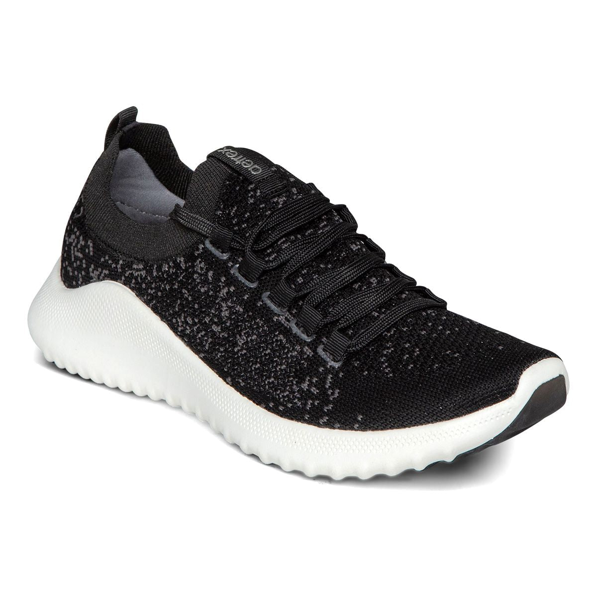 A modern black and white sneaker with breathable mesh upper, white midsole, lace-up front, and low-profile .8-inch heel designed for support and daily comfort.