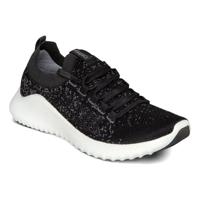 A modern black and white sneaker with breathable mesh upper, white midsole, lace-up front, and low-profile .8-inch heel designed for support and daily comfort.
