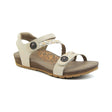 Ivory leather sandal with two wide adjustable hook-and-loop straps across the foot and a padded heel strap, featuring a contoured footbed with visible arch support and a low-profile cork and rubber sole.