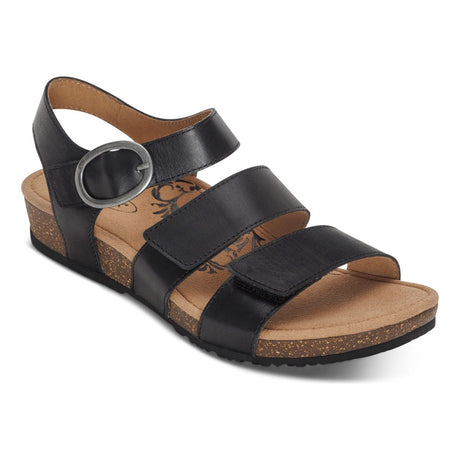 Black leather sandal with cutout detailing, two adjustable hook-and-loop straps, contoured memory foam footbed with arch support and metatarsal relief, and a low cork-rubber sole. Style #SC560W