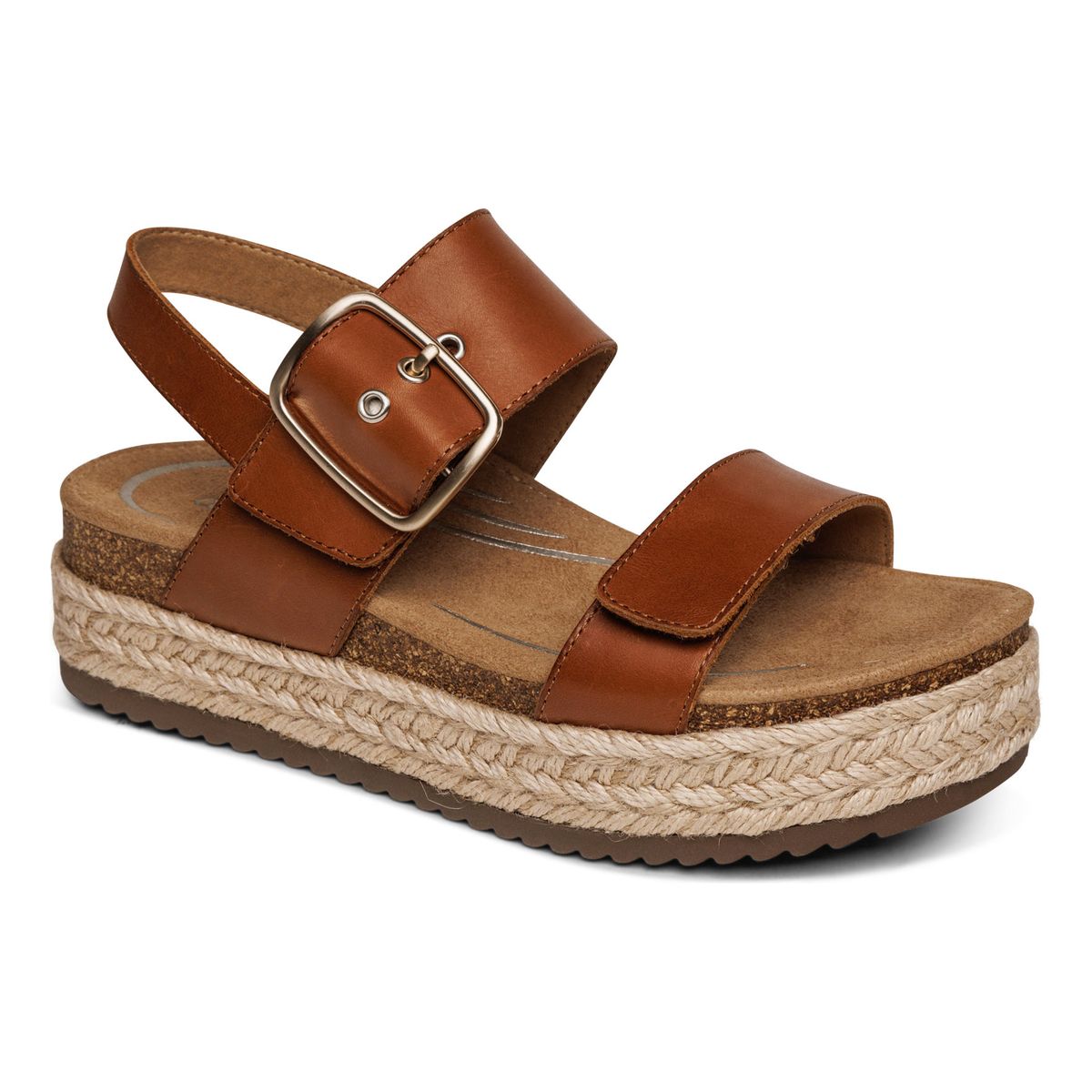 Cognac brown open-toe sandal with two wide leather straps, hook & loop closures, and stretchy gore insert. Designed with a 2-inch wedge heel made of cork and rubber, featuring built-in arch support and a cushioned footbed.