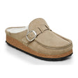 A beige Birkenstock Buckley shearling slipper with a buckle strap and a cork-latex sole.