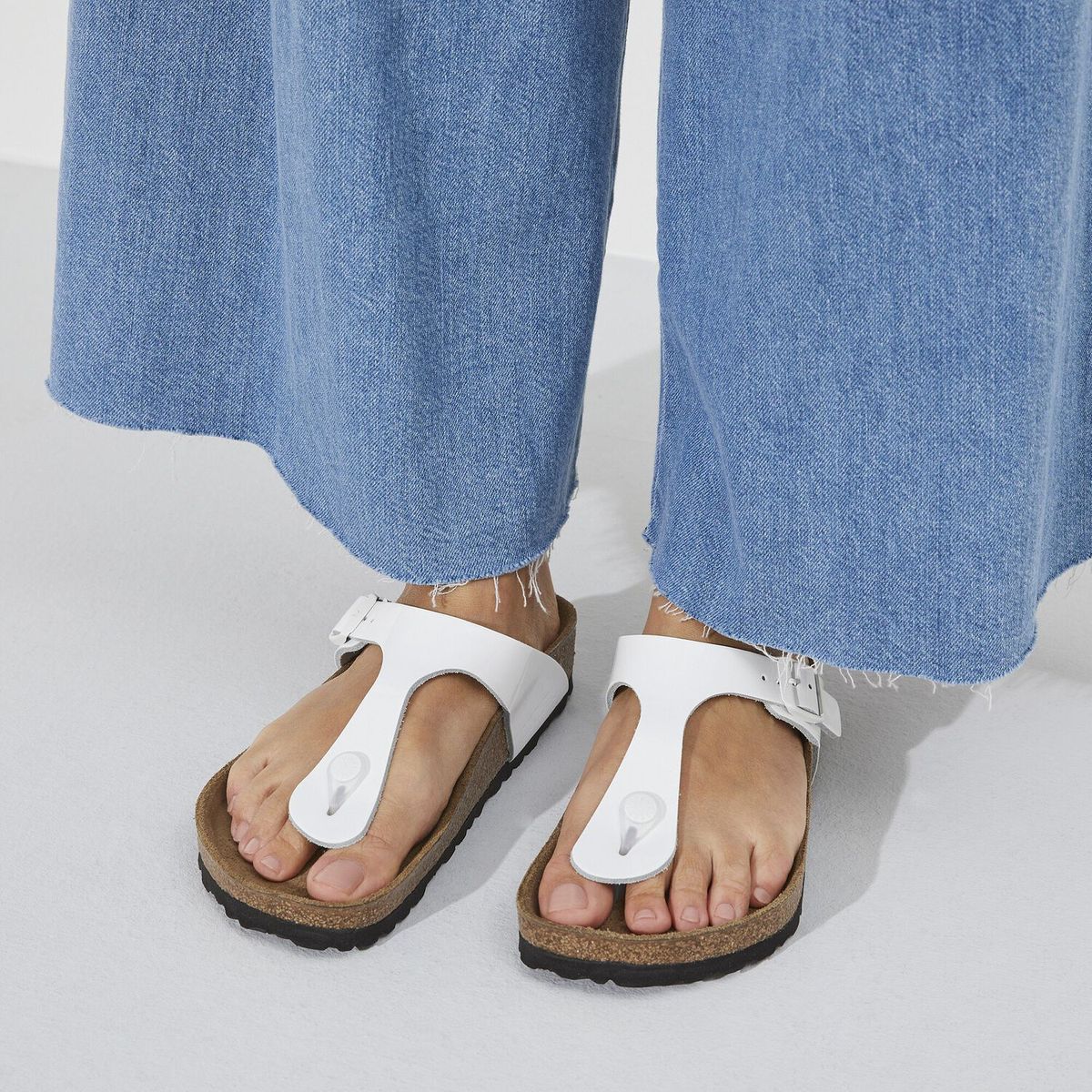 Birkenstock Gizeh sandal in white patent leather with cork footbed and adjustable buckle