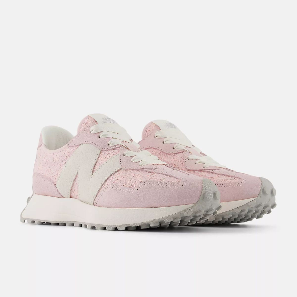 New Balance WS327LCA women’s runners in soft pink with lace detail, suede overlays, and chunky outsole, angled side view.