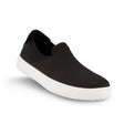 Black Vessi waterproof slip-on sneaker with a knit upper, white sole, and a small teal tag on the heel, SHBWBBW