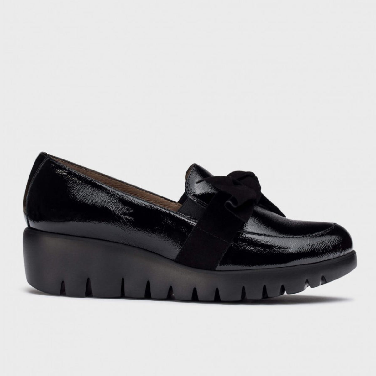 Wonders C33323 women's black patent leather loafer with a suede bow on top and a chunky black wedge sole.