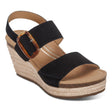 A black leather wedge sandal with a 3-inch jute-wrapped heel, adjustable straps over the toes and ankle, and a cushioned footbed—elegant and supportive for summer wear.