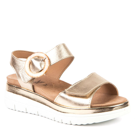 Women’s metallic gold leather platform sandal with a decorative round buckle and a thick white lug sole. Style #AP-12237