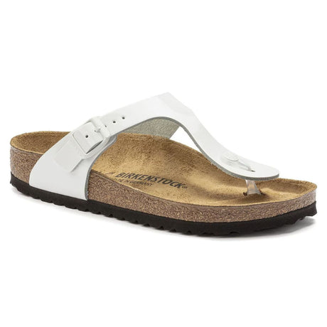 A white Birkenstock sandal with a shiny patent look, featuring natural leather upper, cork footbed, and EVA outsole.