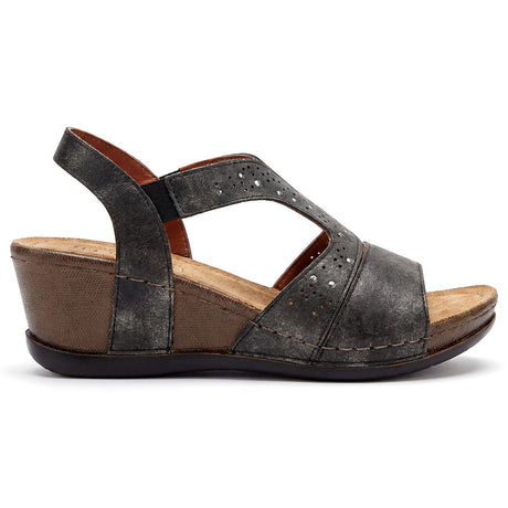 Women's distressed black leather wedge sandal with laser-cut detailing, a T-strap design, and a brown heel. Style #S4122.