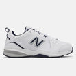 Men's New Balance MX608v5 walking shoe in white leather with navy blue collar and silver logo, featuring a visible ABZORB heel. Style #: MX608WN5