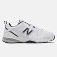 Men's New Balance MX608v5 walking shoe in white leather with navy blue collar and silver logo, featuring a visible ABZORB heel. Style #: MX608WN5