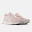 New Balance WS327LCA women’s runners in soft pink with lace detail, suede overlays, and chunky outsole, angled side view.