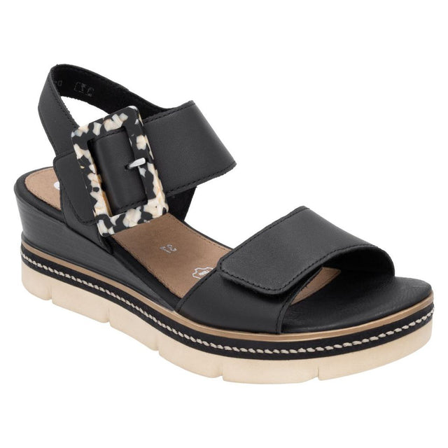 Women’s black leather wedge sandal with a decorative marble-pattern buckle and a beige platform lug sole. Style #D2L53-00