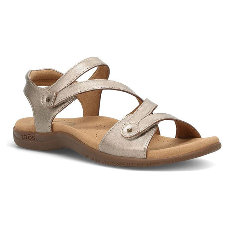 Champagne metallic leather strappy sandal with adjustable hook-and-loop closures and a tan contoured footbed.