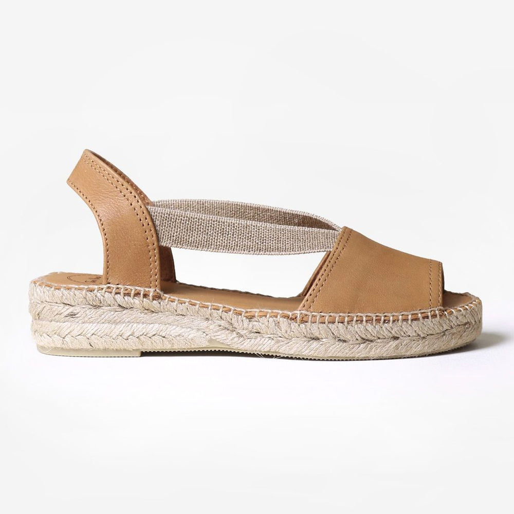 Women’s tan leather flat sandal with elastic cross-straps and a braided jute espadrille sole.