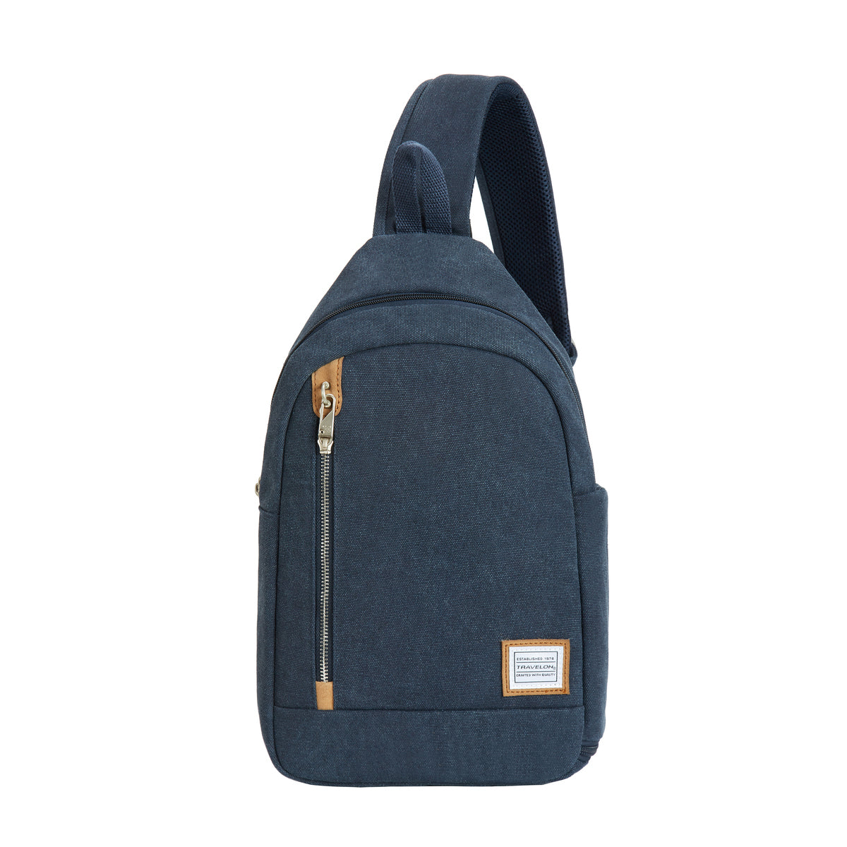 A navy indigo canvas sling bag with a vertical front zipper and tan leather accents. Style # 33604-350