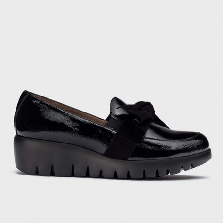 Wonders C33323 women's black patent leather loafer with a suede bow on top and a chunky black wedge sole.