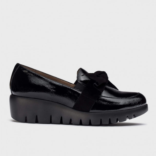 Wonders C33323 women's black patent leather loafer with a suede bow on top and a chunky black wedge sole.